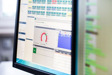 Ein Computerbildschirm zeigt ein Überwachungsdashboard mit Diagrammen und Statistiken zur Systemleistung.